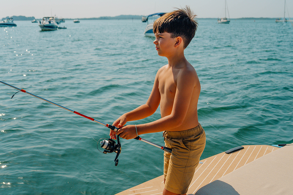 Boy fishing off back of Bellini Astor 36