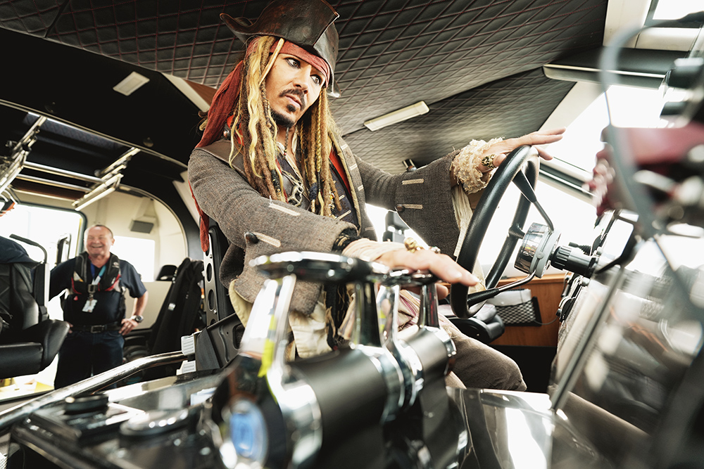 Captain Jack Sparrow lookalike at helm of boat