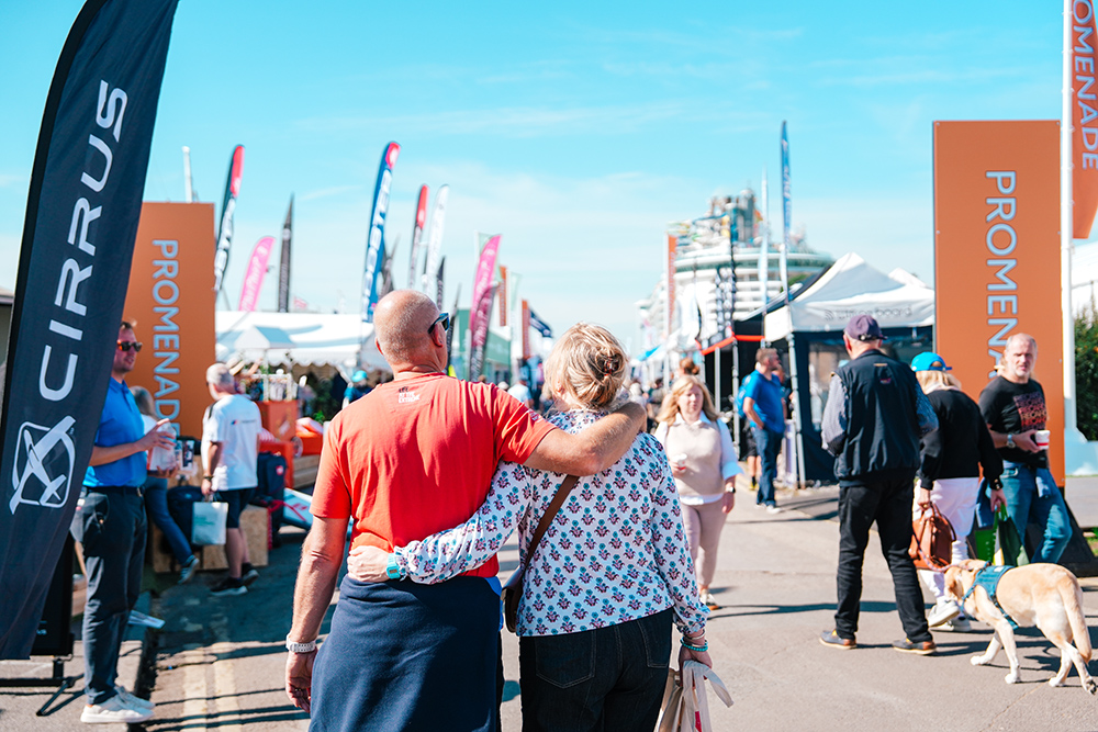 couple arm in arm walking down show pontoons at SIBS25