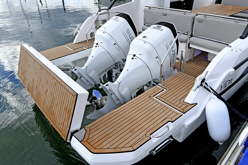 Twin white Suzuki outboard engines mounted on teak swim platform of a Bavaria VIDA 33.