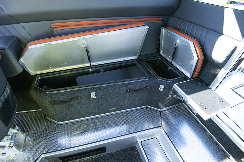 Under-seat storage compartments open inside Ockelbo B25 CAB cabin, showing practical layout.
