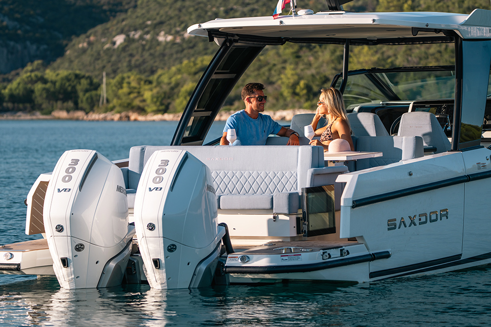 Couple sat on aft dining area of Saxdor 320GTO enjoying a glass of wine