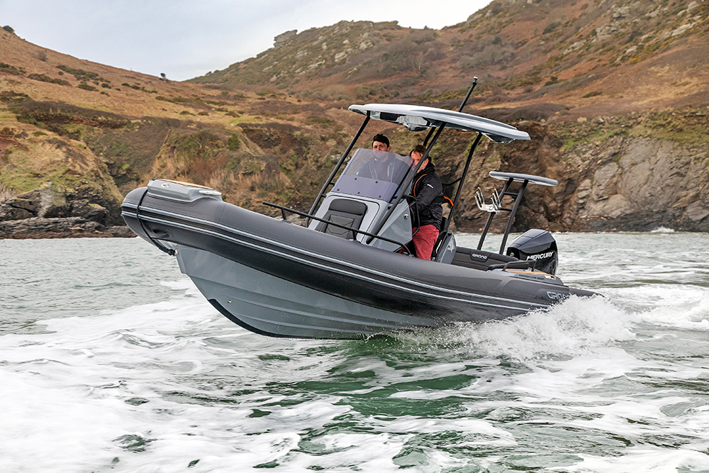 Grand G680 underway with cliffs behind and on green sea.