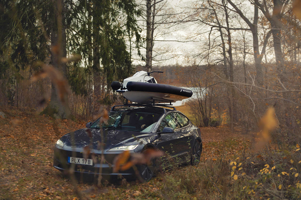 Roxen electric PWC secured on a car roof rack in a woodland setting, highlighting its lightweight portability.