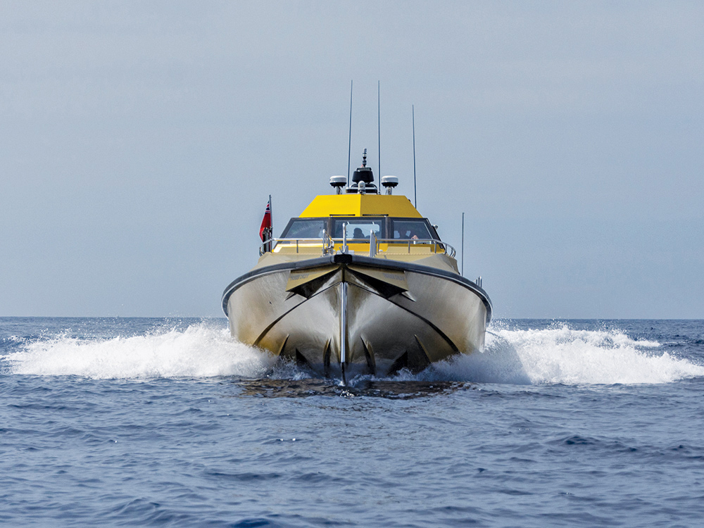 Thunder Child II trimaran powering forward at speed, lifting through calm offshore water.
