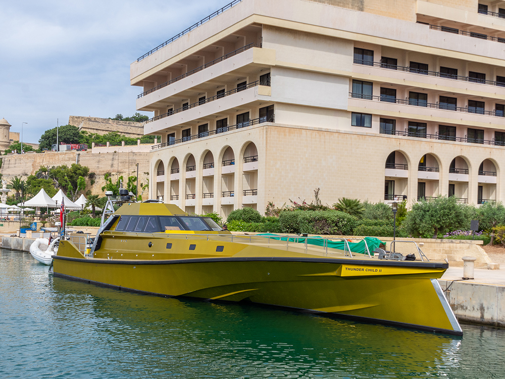 Thunder Child II moored beside a waterfront hotel, showing its angular trimaran hull.