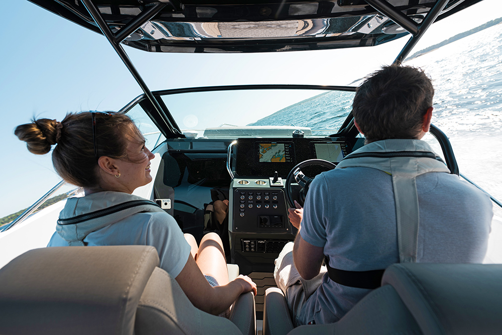 Couple sat at the helm of the Nordkapp Enduro 830 whilst turning to starboard