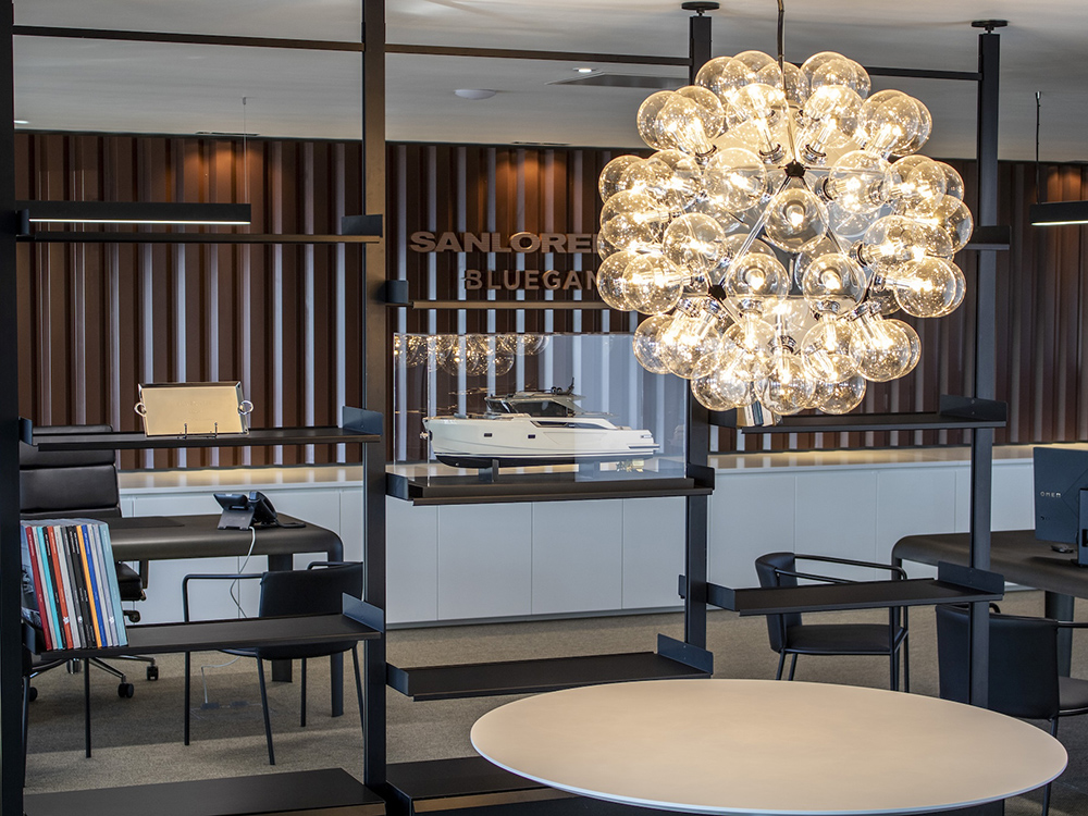 Sanlorenzo showroom interior with yacht scale model, bespoke furniture and contemporary lighting.