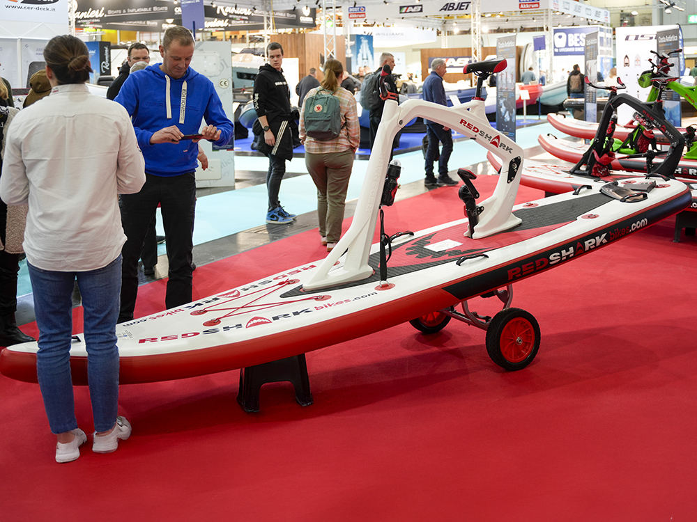 Visitors examine Red Shark pedal powered boards on display at a boot Düsseldorf.