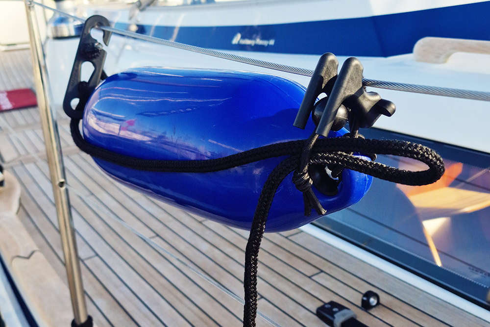 Two Fendermate clips attaching a bright blue fender horizontally at both ends
