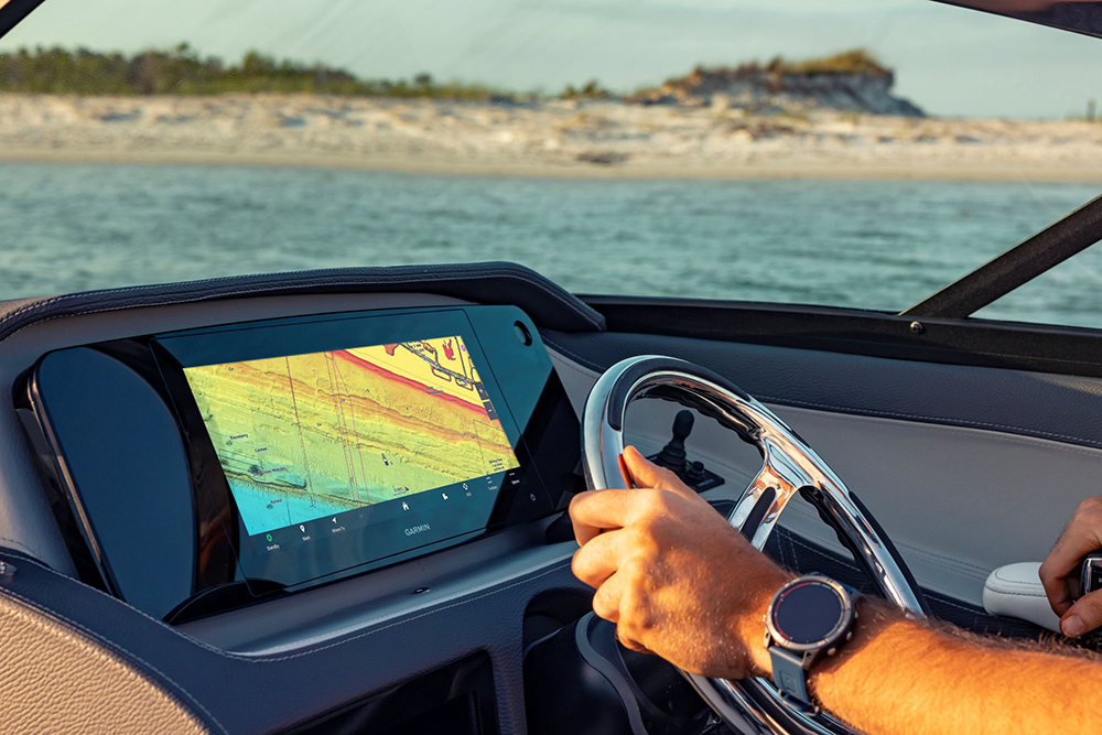 Garmin Ultrawide installed on dash of boat with mans hands on a steering wheel