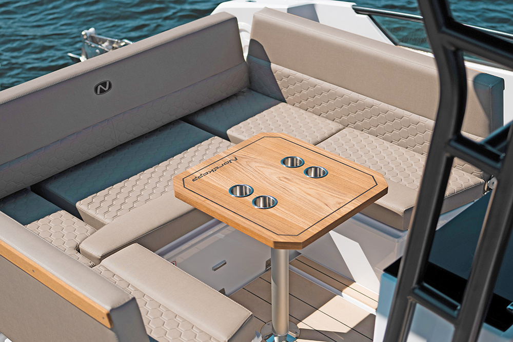 Nordkapp Enduro 30 aft dining area with beige seating and teak table