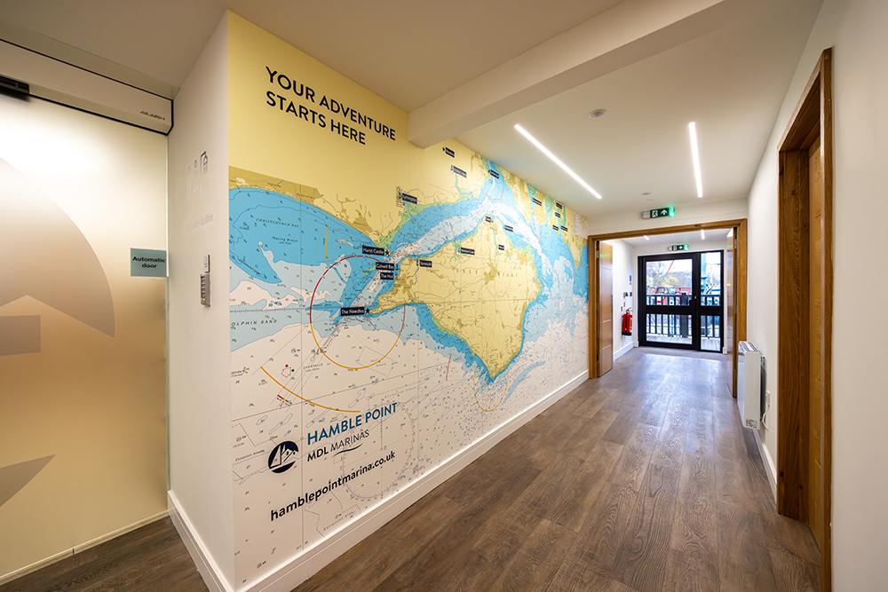 Hamble Point Marina office corridor featuring a large nautical chart wall graphic highlighting local cruising routes and destinations.