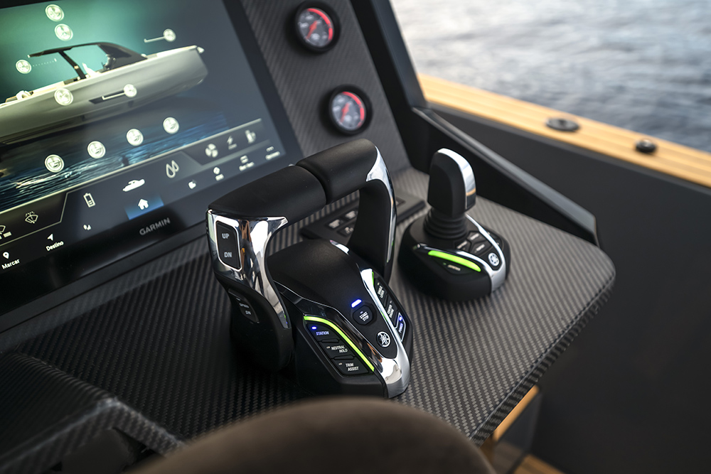 Detail of the Maxim Yachts Max 44R helm with Yamaha throttle controls, joystick and carbon-fibre console finish.