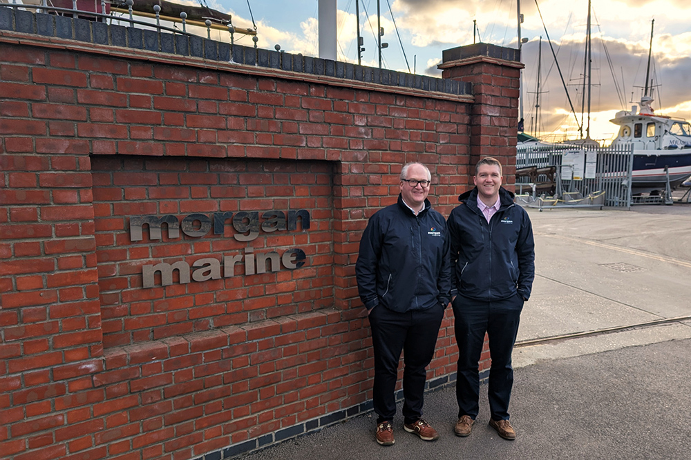 Two Morgan Marine team members outside the Brightlingsea marina entrance, marking the formation of Morgans Group following the Fox’s acquisition.