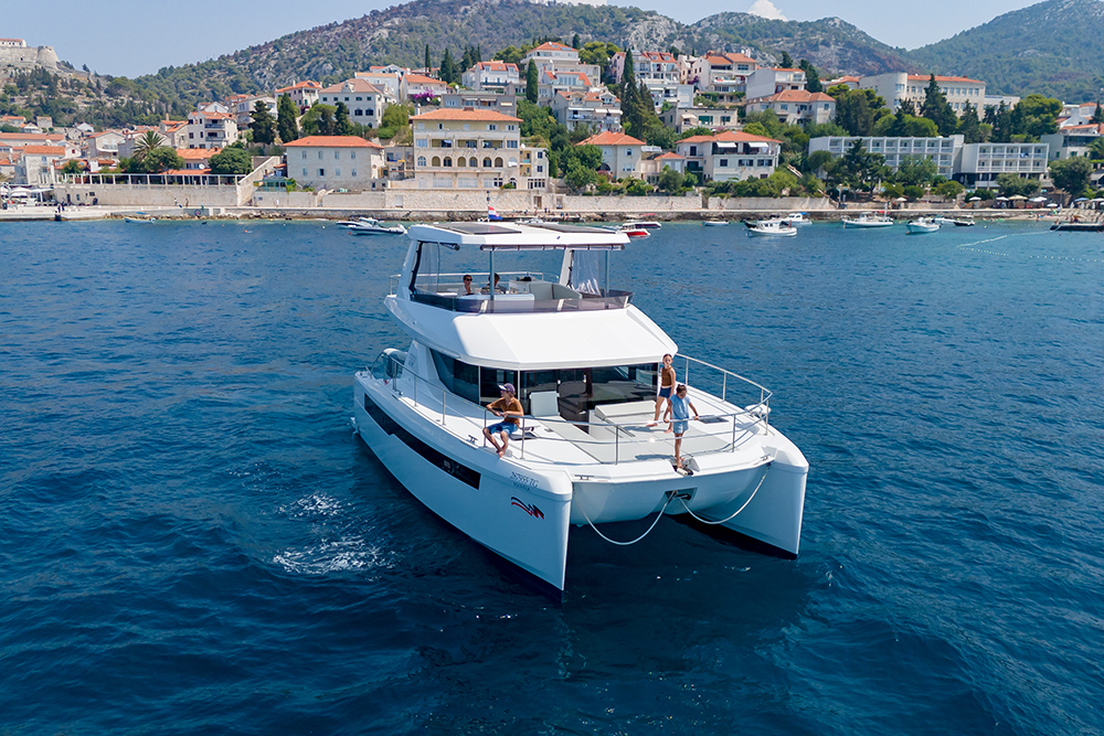 Power catamara moored up in the bay off a Mediterranean harbour town