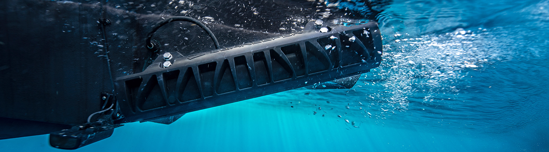 Underwater view of fitted Seakeeper RIDE underway in turquoise sea with white bubbles.