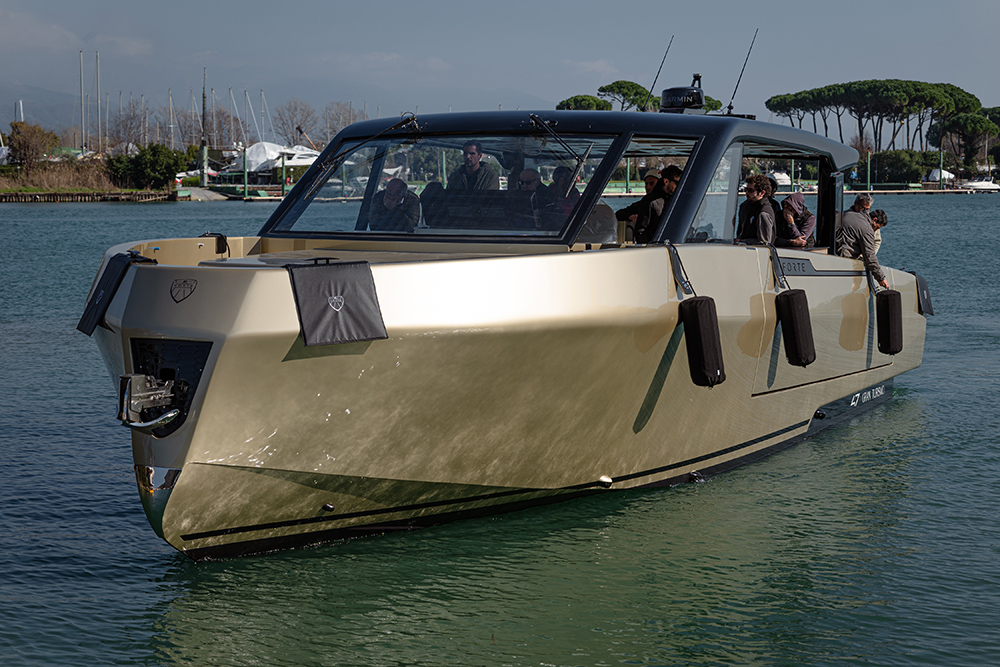 Forte 47 Gran Turismo aluminium yacht underway with guests aboard, highlighting angular hull design and enclosed cockpit layout.