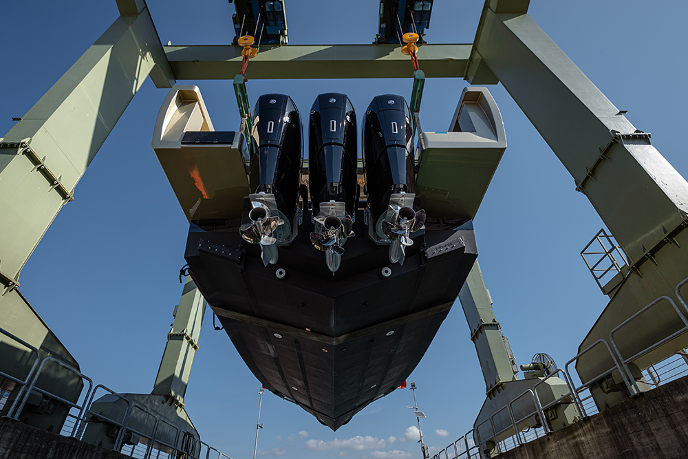 Forte 47 Gran Turismo lifted by travel hoist, showing triple Mercury Verado V12 outboards and deep-V aluminium hull profile.
