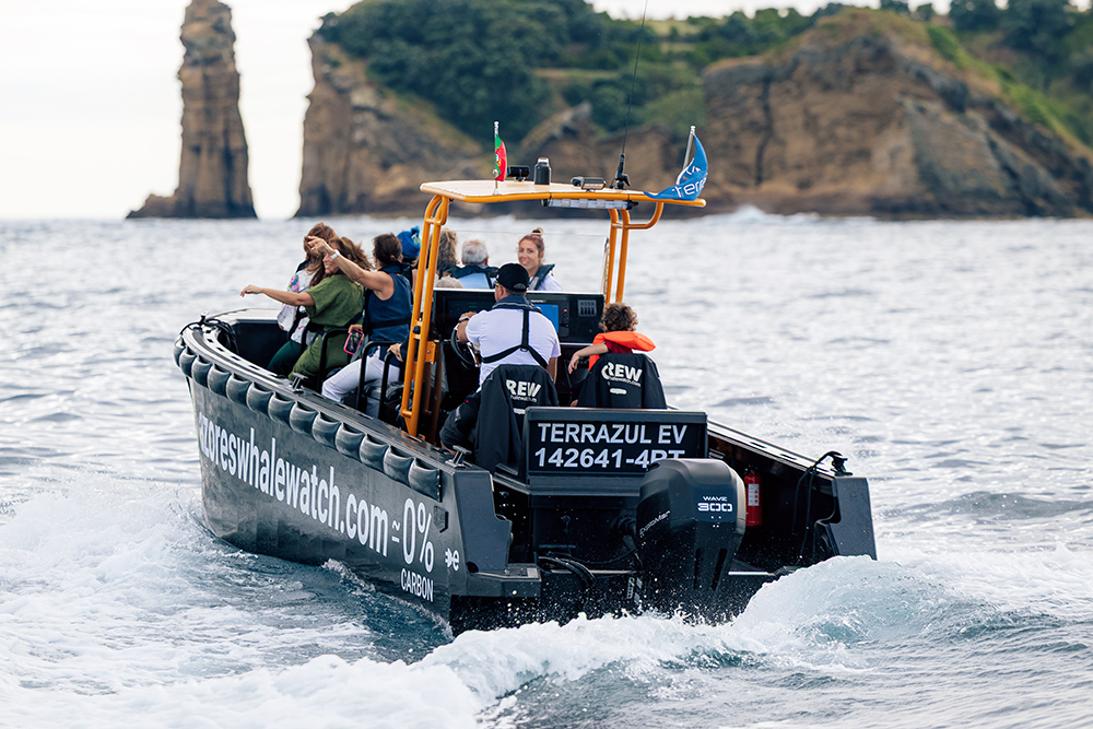 Rigid bouyancy boat branded as whale tourism craft making way off the island of Sao Miguel in the Azores with tourists on board