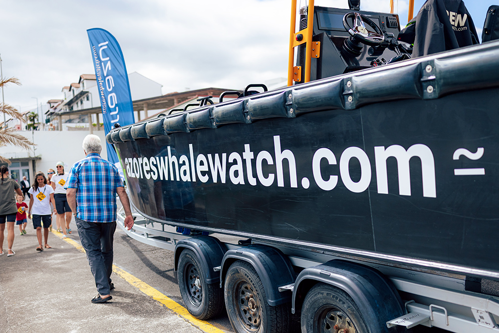 Side of a black boat on a trailer with writing saying azoreswhalewatch.com