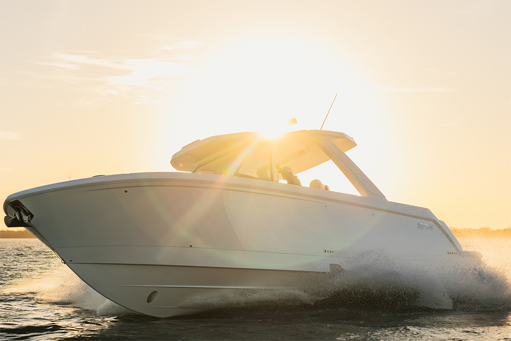 Intrepid 35 Panacea offshore powerboat running at speed with spray and sunset backlight.