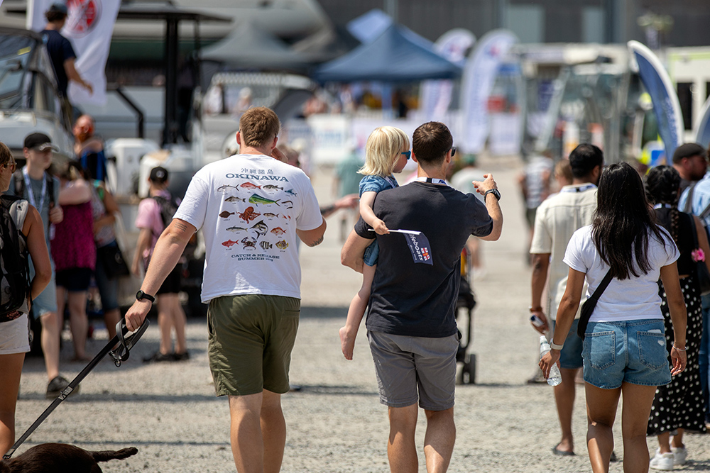 Visitors walking through Plymouth Boat Fest, families exploring exhibitors, boats and marine displays at the marina