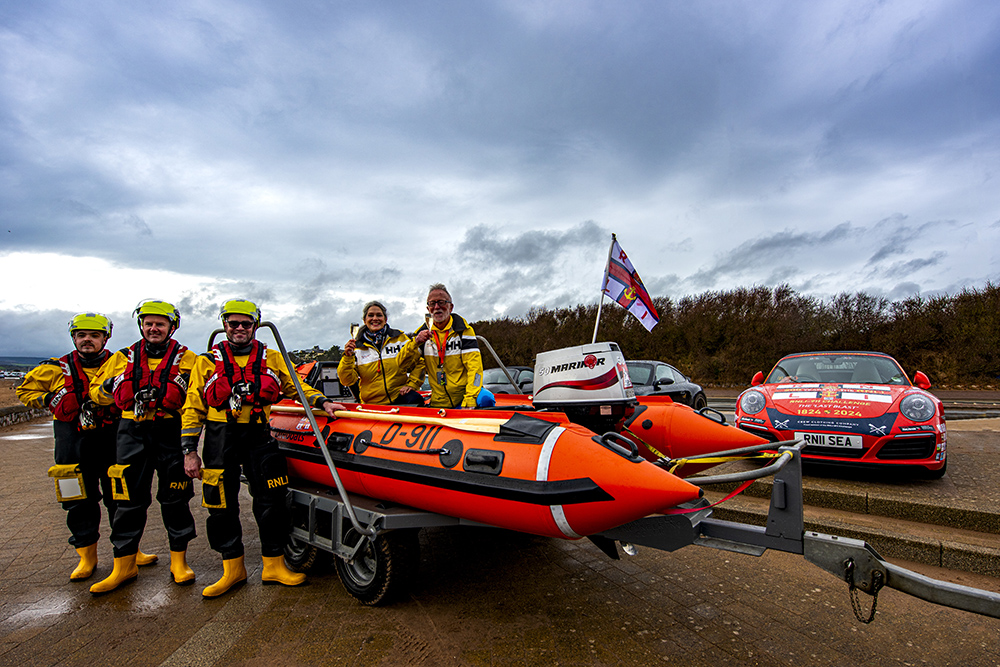 RNLI crew with D lifeboat on trailer at Exmouth beside Porsche 911 used to raise funds for RNLI 911 Challenge lifeboat.