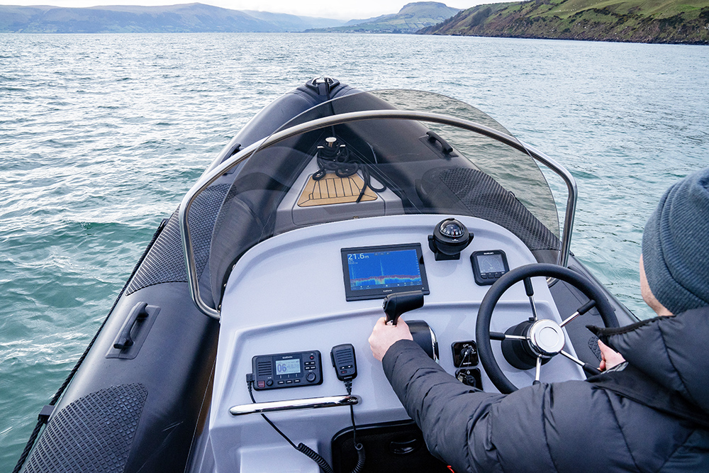 Helm view of Redbay Stormforce 650 RIB underway, showing console, electronics and offshore coastline ahead