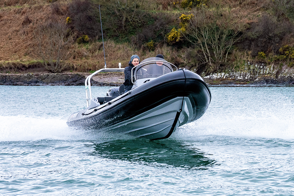 Redbay Stormforce 650 RIB riding high at speed, showing deep-V hull and offshore handling near rocky coastline