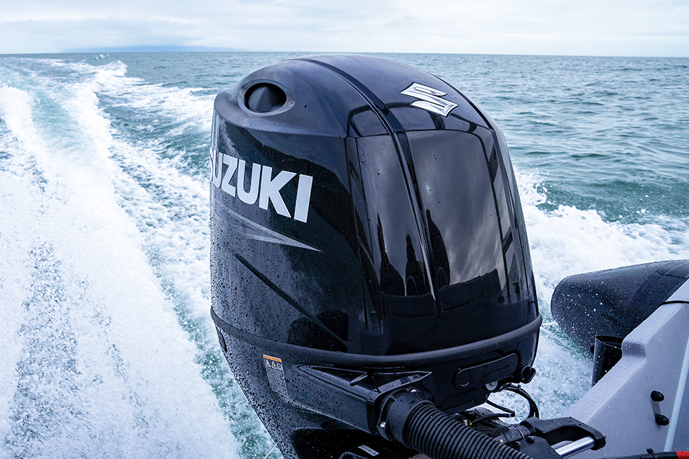 Suzuki outboard powering Redbay Stormforce 650 RIB at speed, with wake trailing across open water