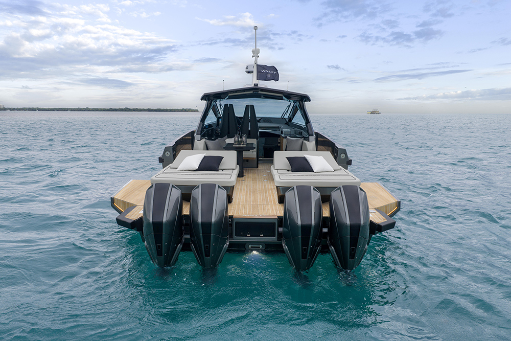 Stern view of the Wally wallypower50X showing four Mercury outboards, teak deck, sunpads and fold-down terraces at sea.