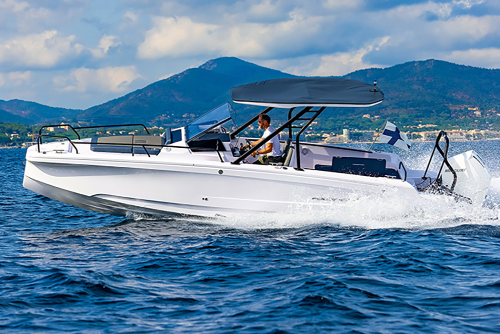 Axopar 25 centre console speeding across coastal waters with canopy, outboard power and mountainous shoreline backdrop
