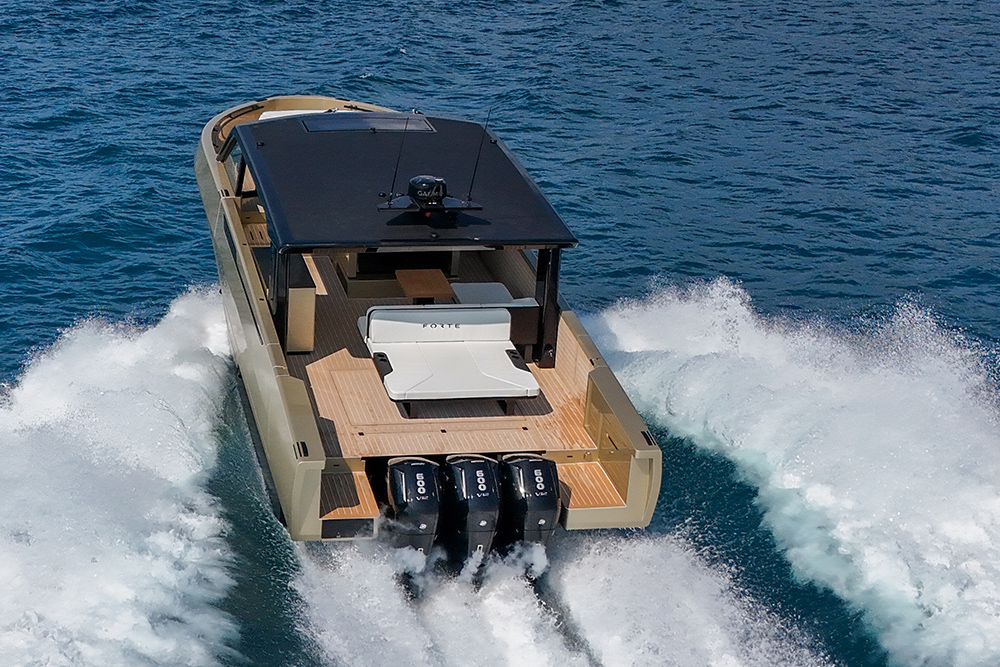 Forte 47 Gran Turismo underway at speed with triple outboards, showcasing open aft deck and expansive cockpit layout