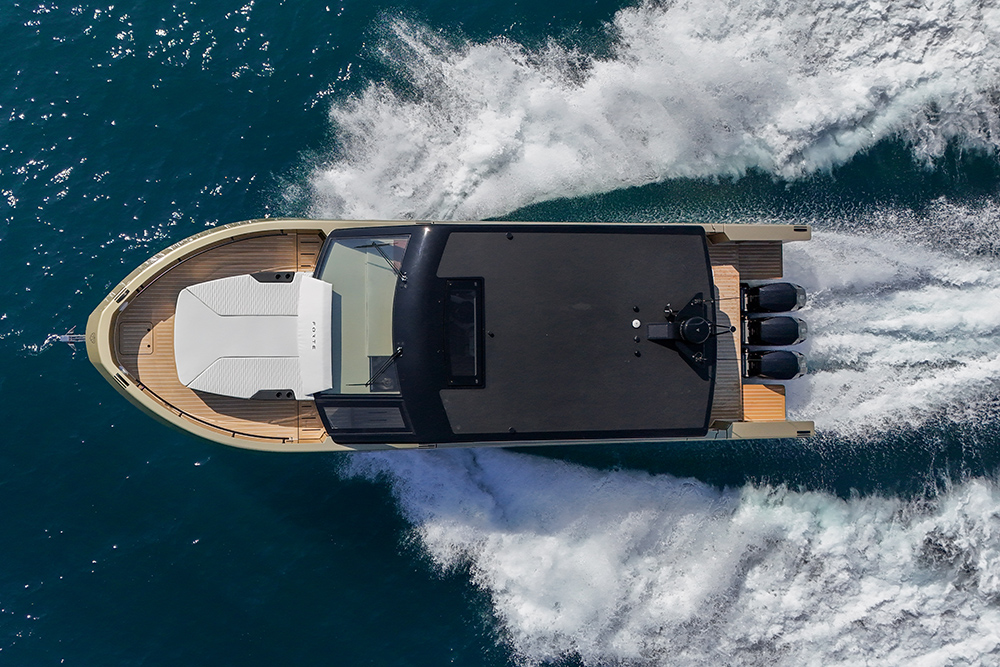 Aerial view of Forte 47 Gran Turismo at speed, showing full deck layout and triple outboards leaving a clean wake