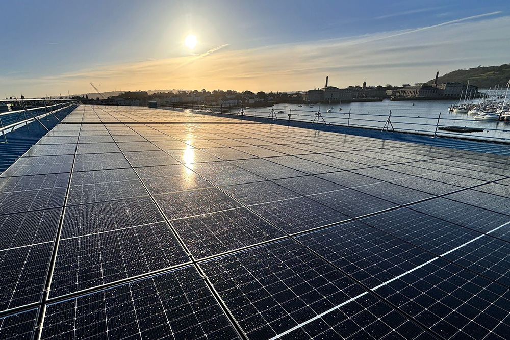 Rooftop solar panels at Princess Yachts shipyard overlooking waterfront, generating renewable energy for marine manufacturing