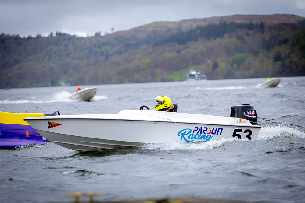 Parsun Racing GT Mono boat competing on Windermere during sustainable powerboat race, driver in helmet at speed on choppy water.
