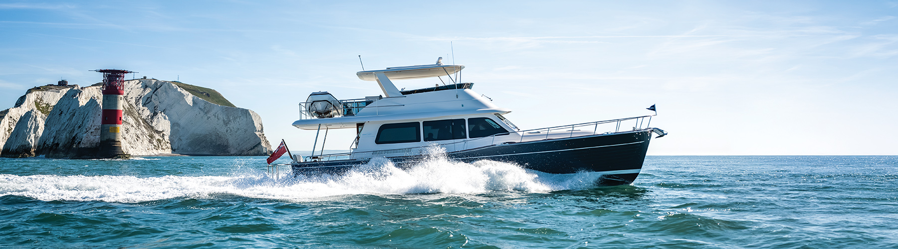 The Grand Banks 54 motoryacht making way on a turquoise sea with white wake behind