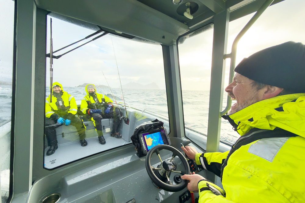 Helmsman laughing whilst at the wheel of T-Top open boat