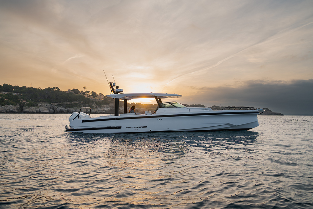 Axopar 38 Sun Top at anchor during sunset, showcasing its open-air design and sleek twin-stepped hull