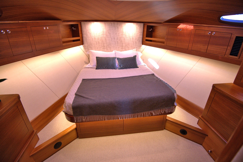 Island bed with bed throw and cream upholstery in GB54 master cabin