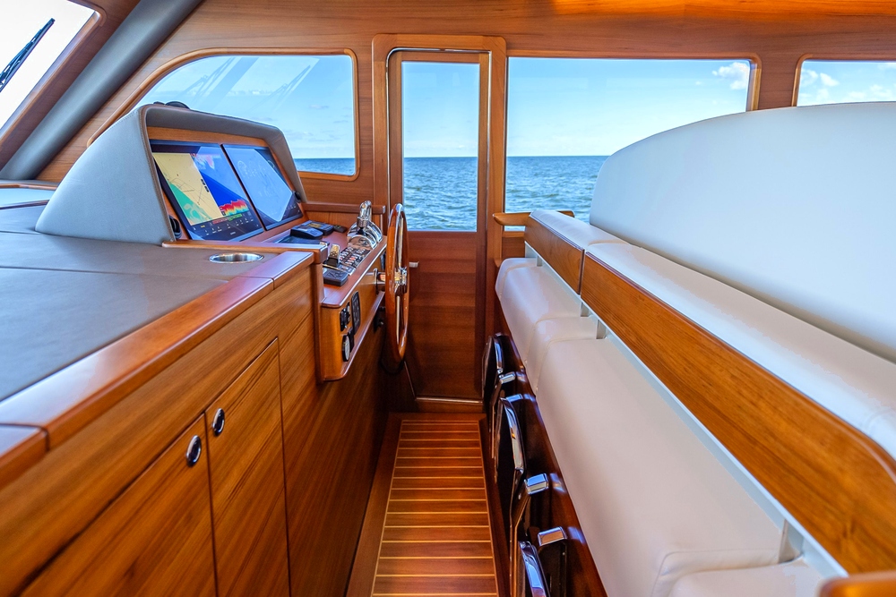 Helm station in the Grand Banks 54 with beautiful wood surround and cream upholstery to seating