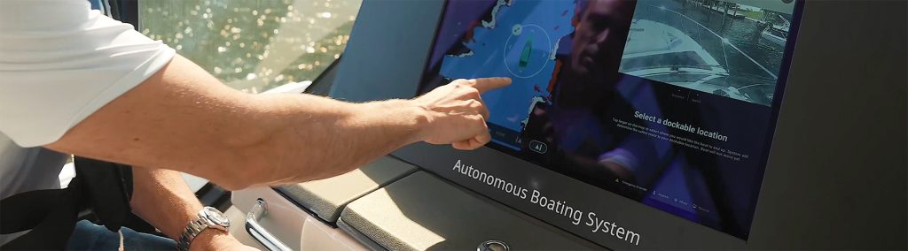 Man at helm using Simrad AutoCaptain autonomous docking system