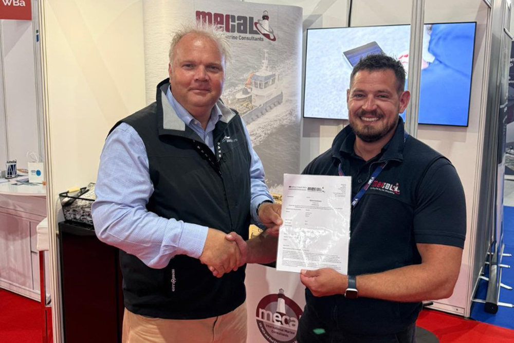 ZeroUSV and MECAL representatives shaking hands while presenting Oceanus12 WB3 certification at a marine trade stand.