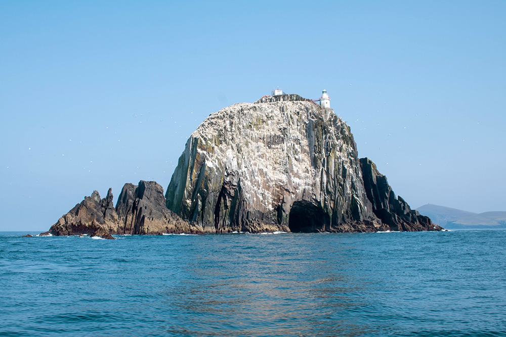Bull Rock in Ireland showing white lighthouse on top right of rock