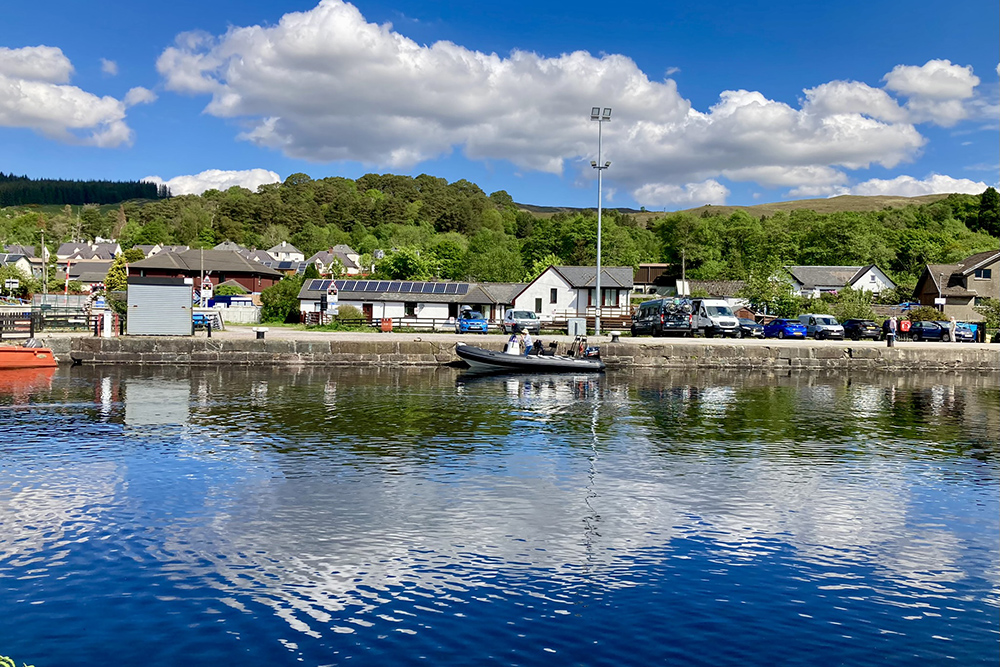 RIB crossing Corpach sea lock basin on the Caledonian Canal under bright Highland skies