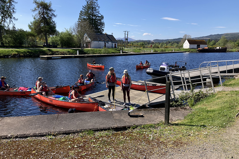 Canoeists and a RIB waiting at the top lock in Fort Augustus on the Caledonian Canal