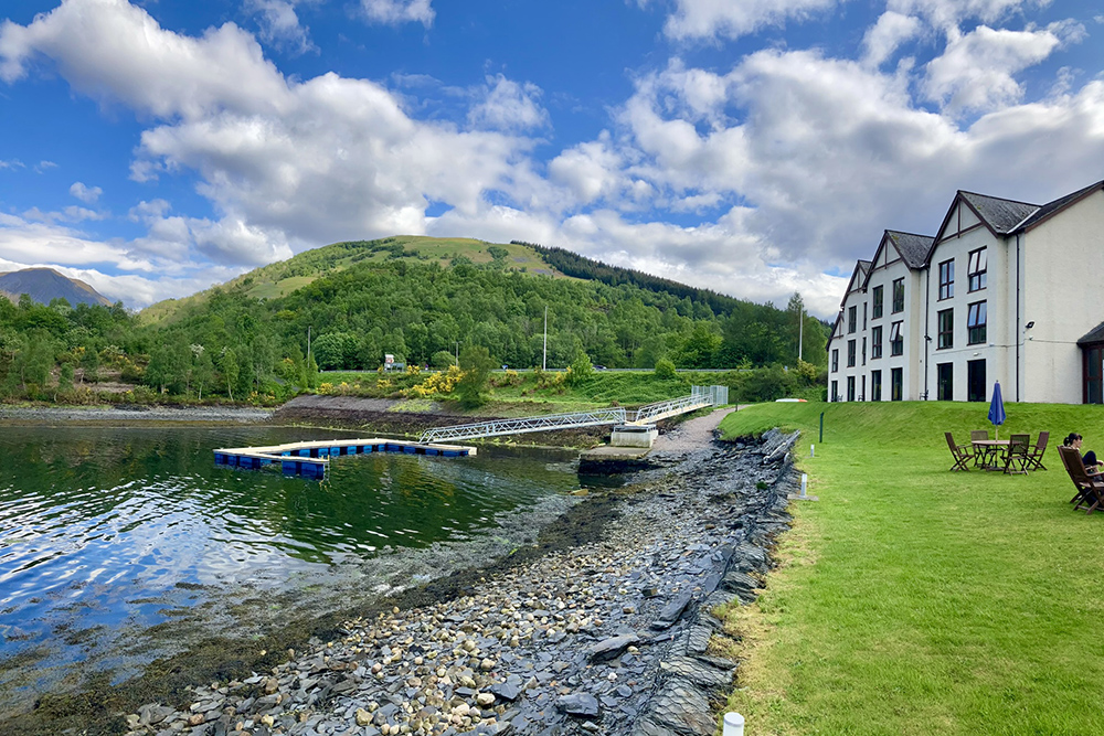 Isles of Glencoe Hotel moorings on Loch Leven, with Highland hills and shoreline pontoons nearby