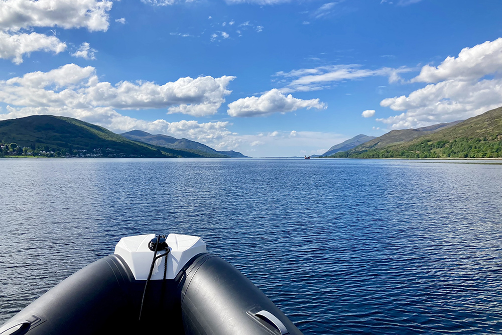 RIB bow crossing Loch Linnhe on the homeward run, with Highland hills under bright skies