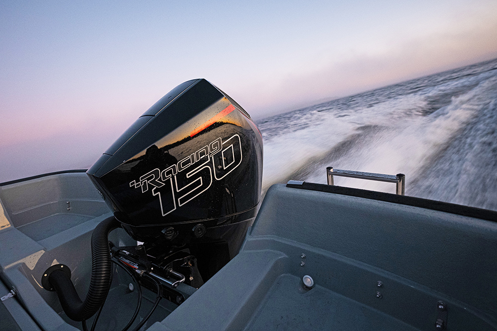 Merury Racing 150hop outboard on the stern of the Sting725 Pro with a wake flowing astern in evening pink light